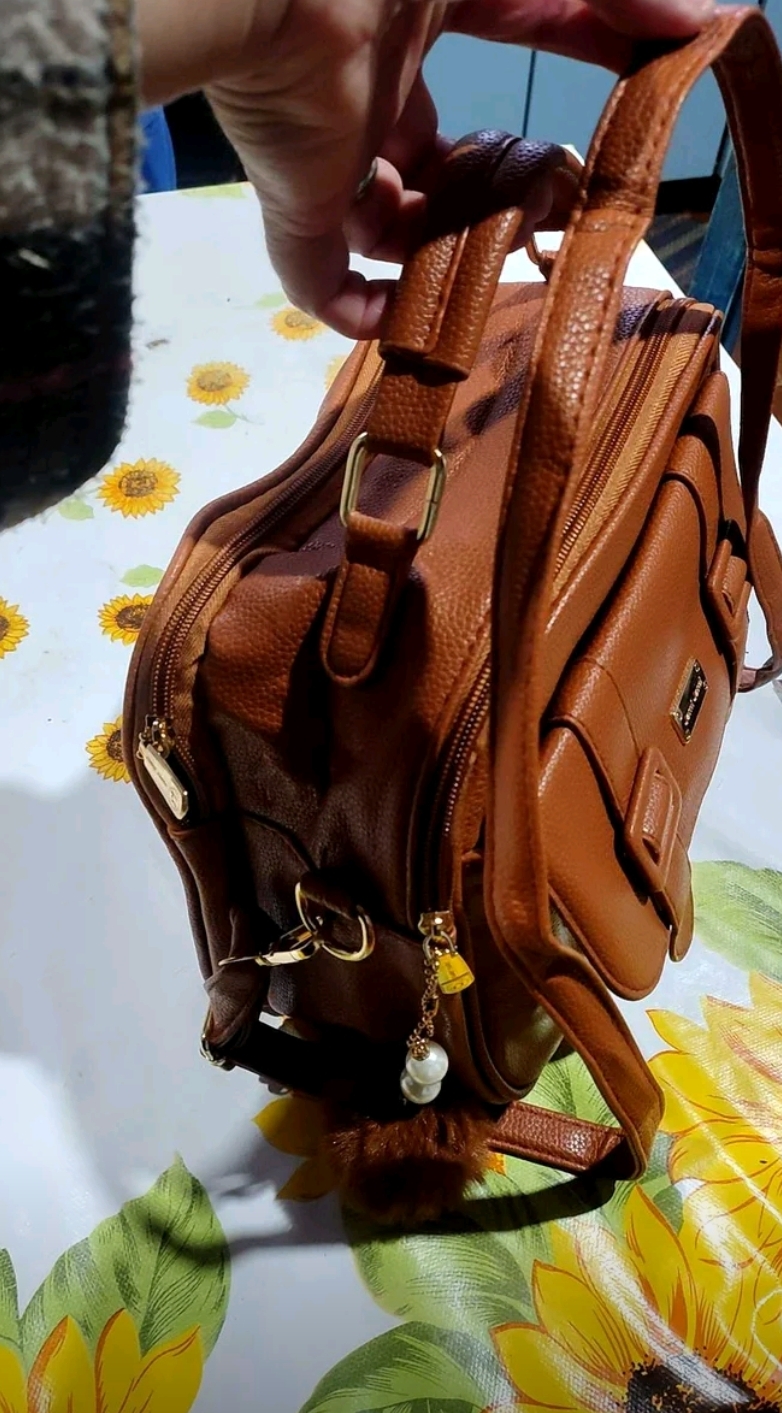 Detalhe lateral da bolsa Amelise coffee em avaliação